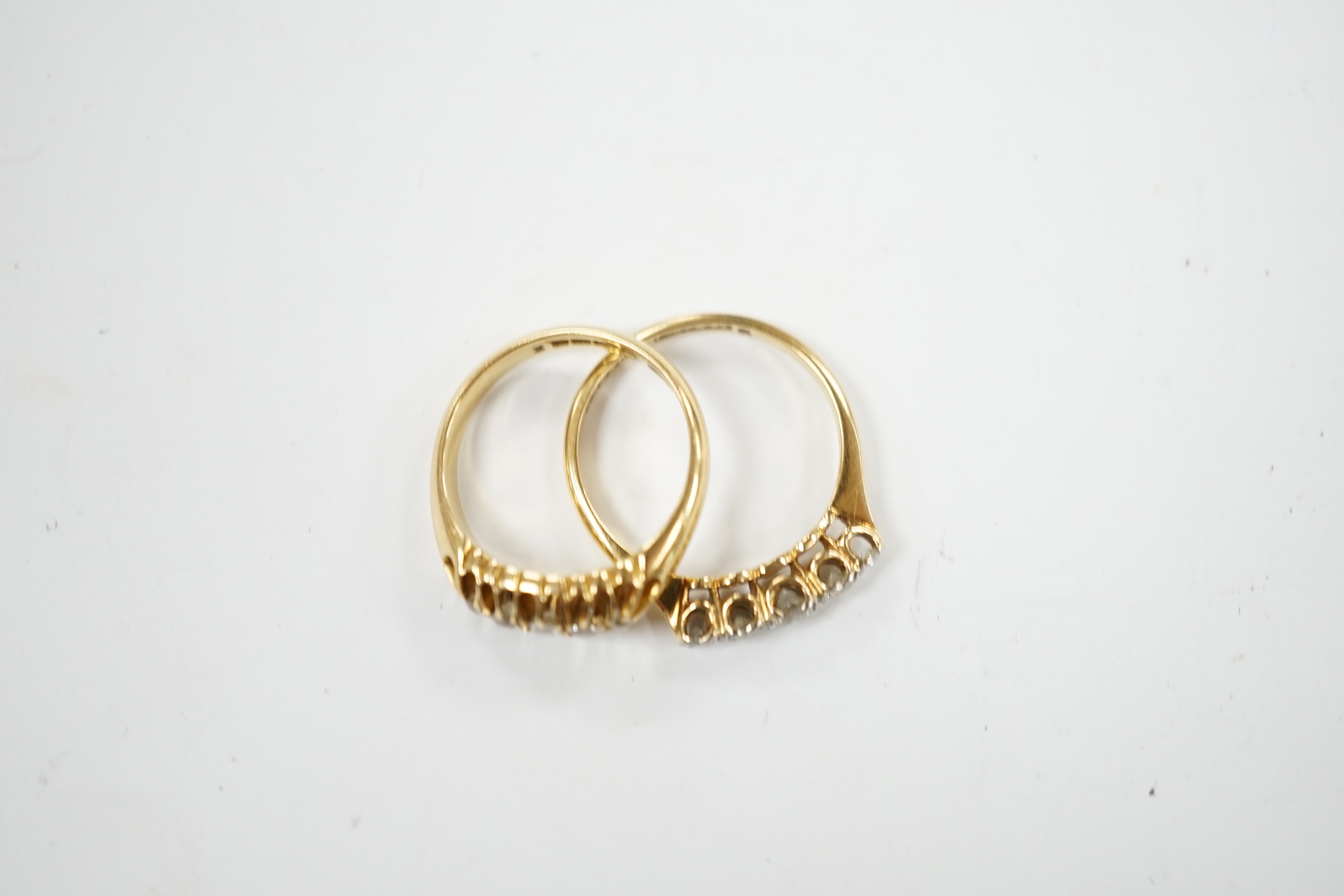 Two early 20th century 18ct gold and graduated five stone diamond set half hoop rings